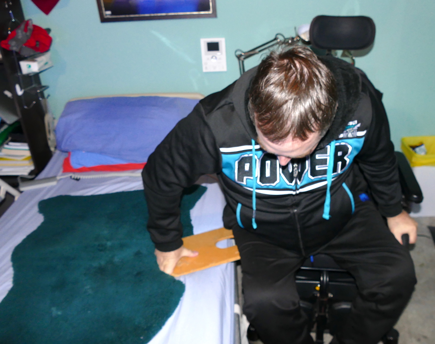 john getting onto bed from wheelchair usiing a slideboard - sci sleeping tips