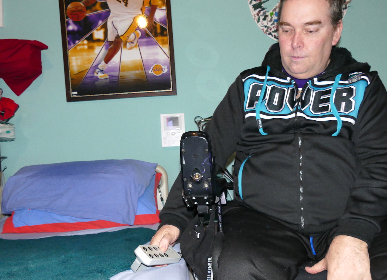 shows john in his powerchair adjusting height of bed - sci sleeping tips