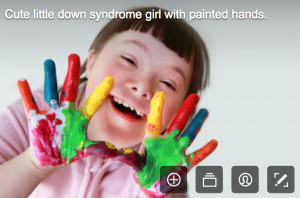 disability stock photographs - young girl with down syndrome who has hands painted in mulit colours 