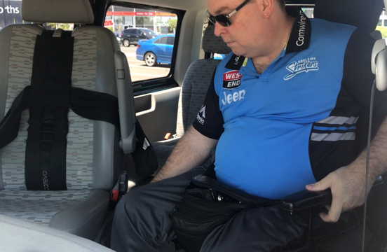 I am sitting in my wheelchair. blue shirt. my belly is sticking out but I've lost weight since then I promise. I am looking at the drivers seat - SCI driving