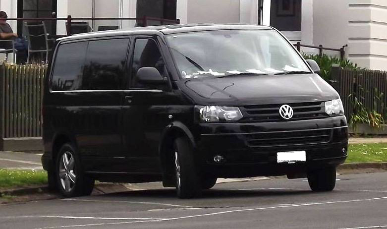 a black vw transport parked in a street - SCI driving