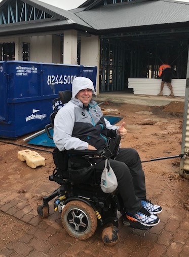 I am smiling and on my mud coated wheelchair, as I was stuck in the mud