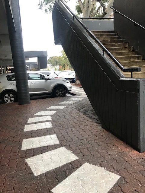 The stairwell is to the right. The path indicates where you should go, but if you follow it in a wheelchair, you can hit your head