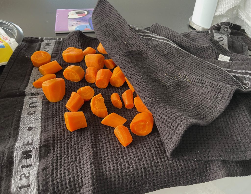 the orange carrots are being dried by tea towels