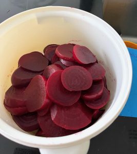 pickling beetroot - sliced beetroot in a white plastic container