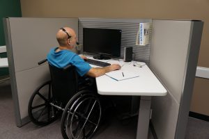 Wheelchair user working at an accessible office workstation