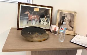 How to use ChatGPT to write a eulogy - Harness racing photographs, trophies and family memorabilia displayed at Alec Duthie's funeral.
